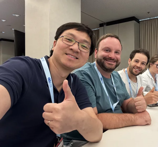 A selfie of three young urologists giving a thumbs up