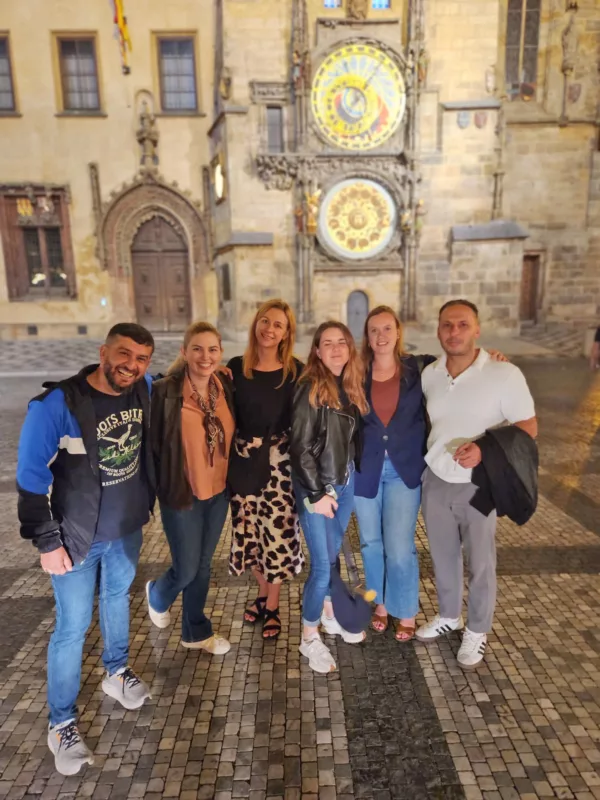 Group of young urologists standing next to each other in front of the Prague Astronomical Clock