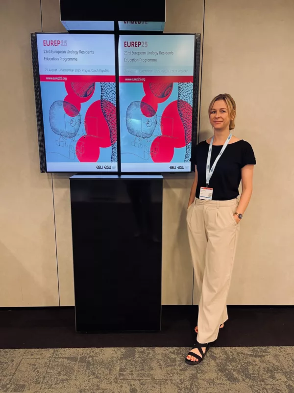 Young female urologist standing next to a sign