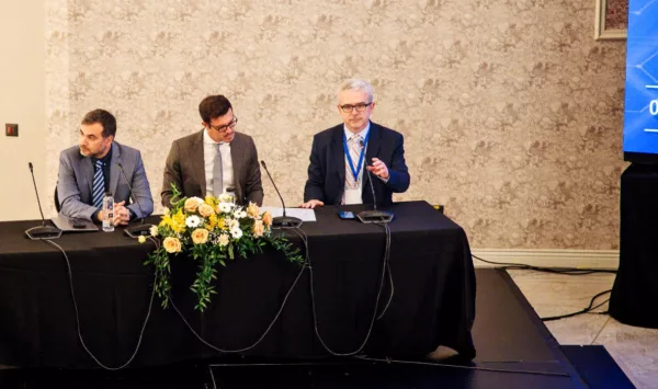 three men as panel members seated by the table