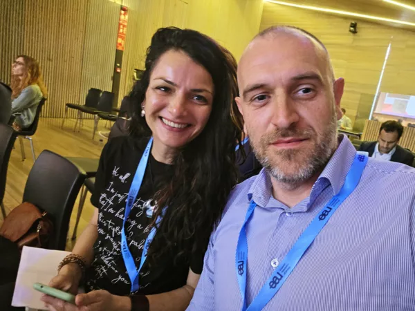 Man and woman wearing lanyards at a conference